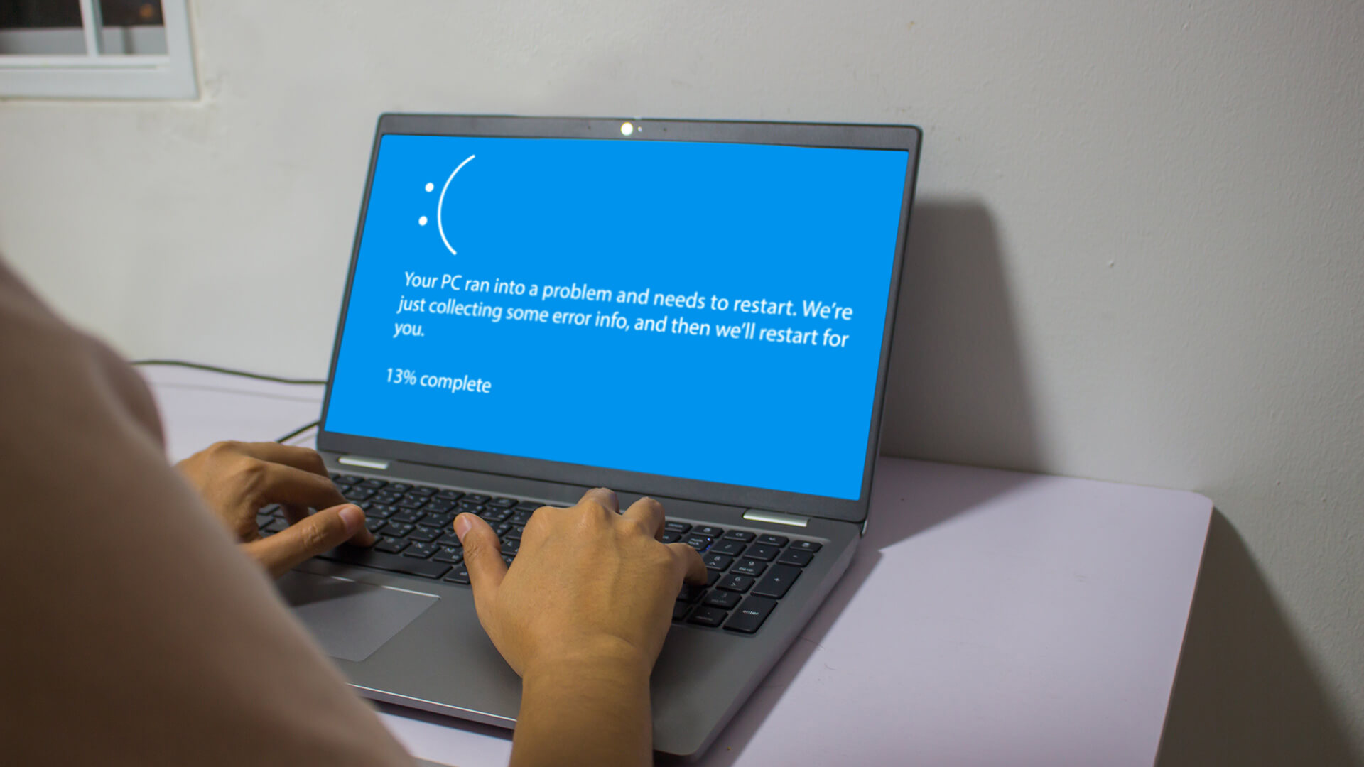 Computador com tela azul exibindo erro do sistema Windows, indicando problema com o PC